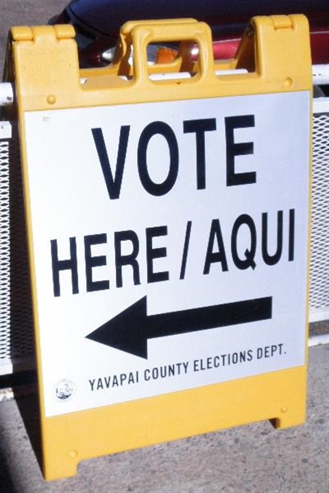 Photo of Yellow and White Vote Here Sign